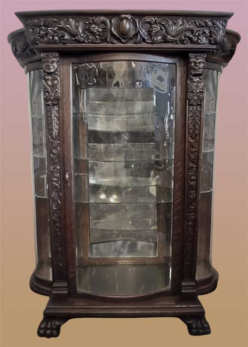 carved oak China cabinet with mythical faces