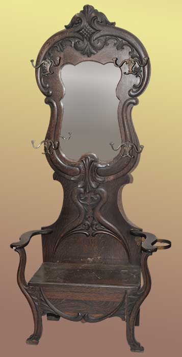 carved oak hall tree with shaped mirror